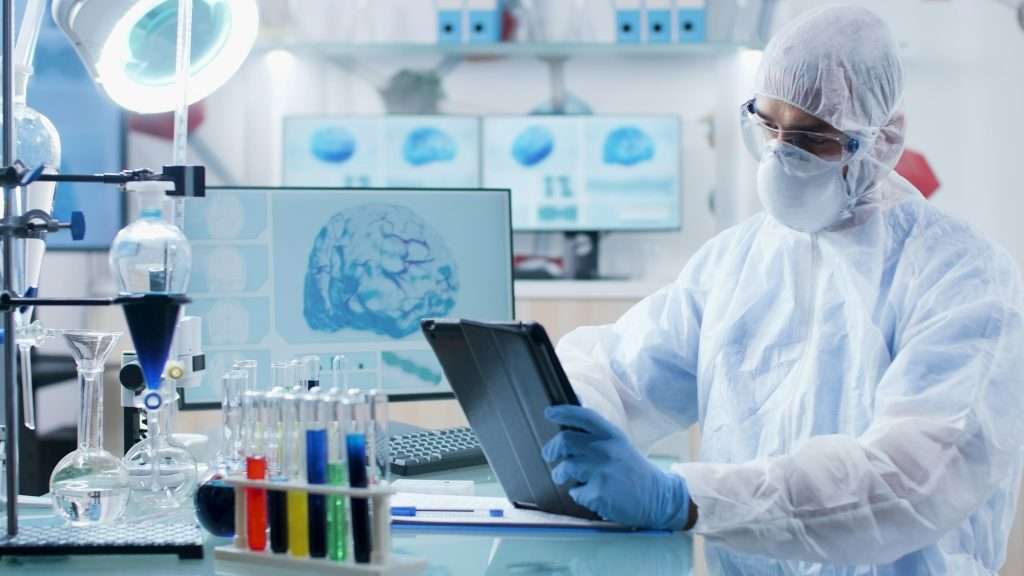 Doctor researcher with ppe equipment holding tablet computer analyzing disease diagnostic